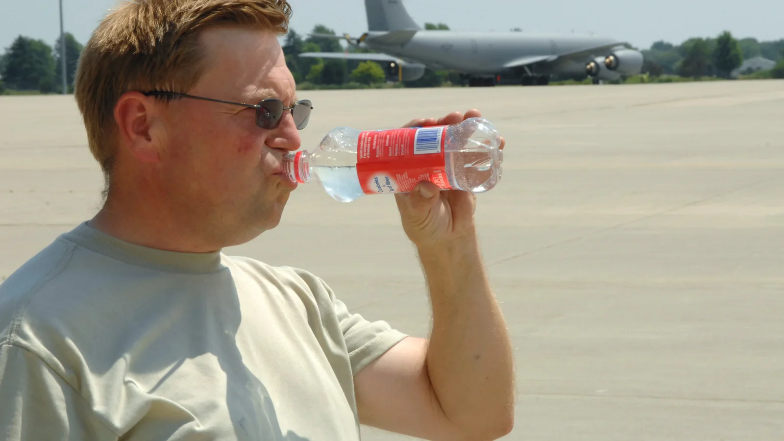 A worker takes a drink after a long shift outdoors in a heat wave